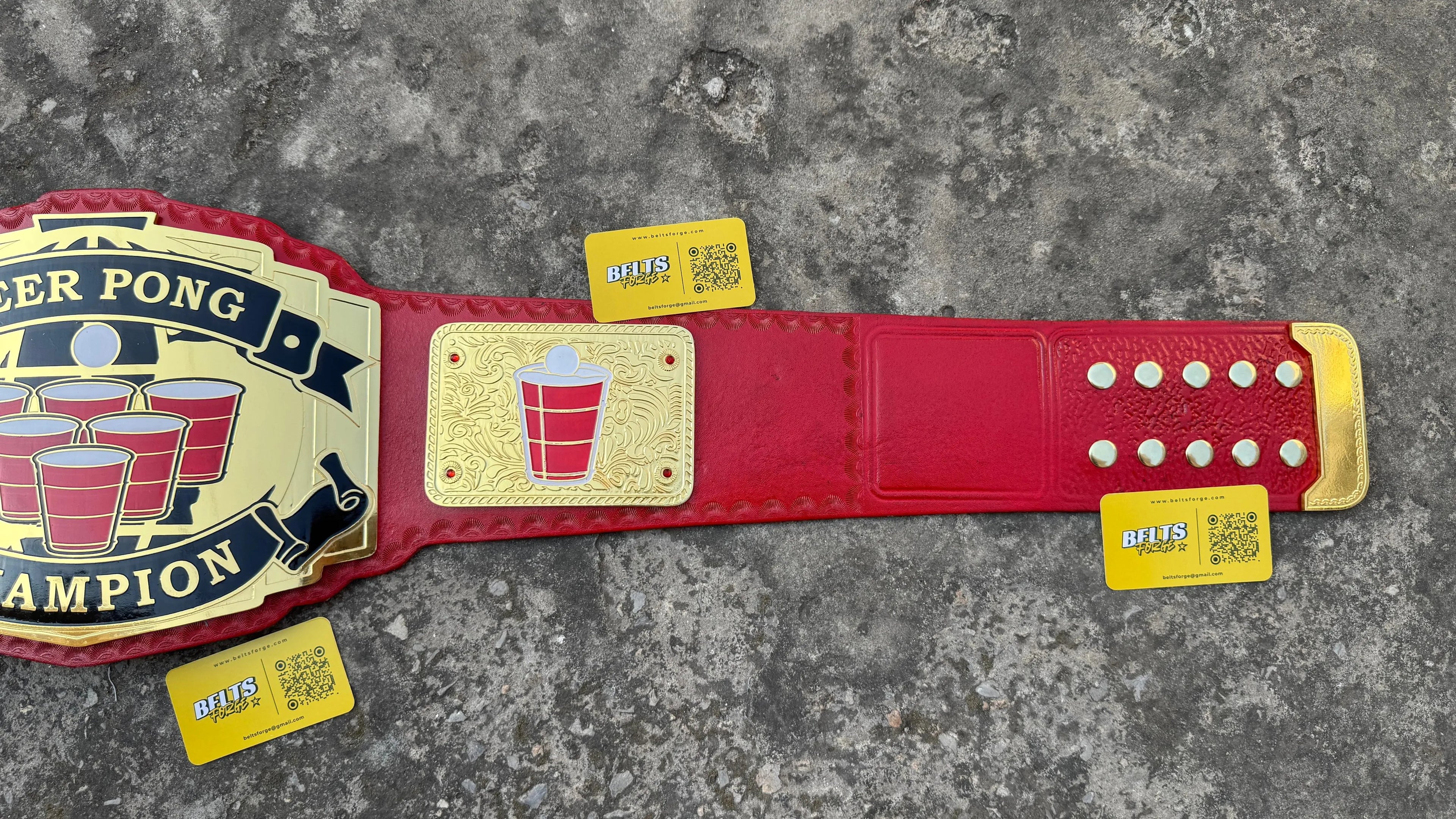 Beer Pong Champion Novelty Belt side plate and strap view showing gold-plated brass side plate on genuine red leather strap