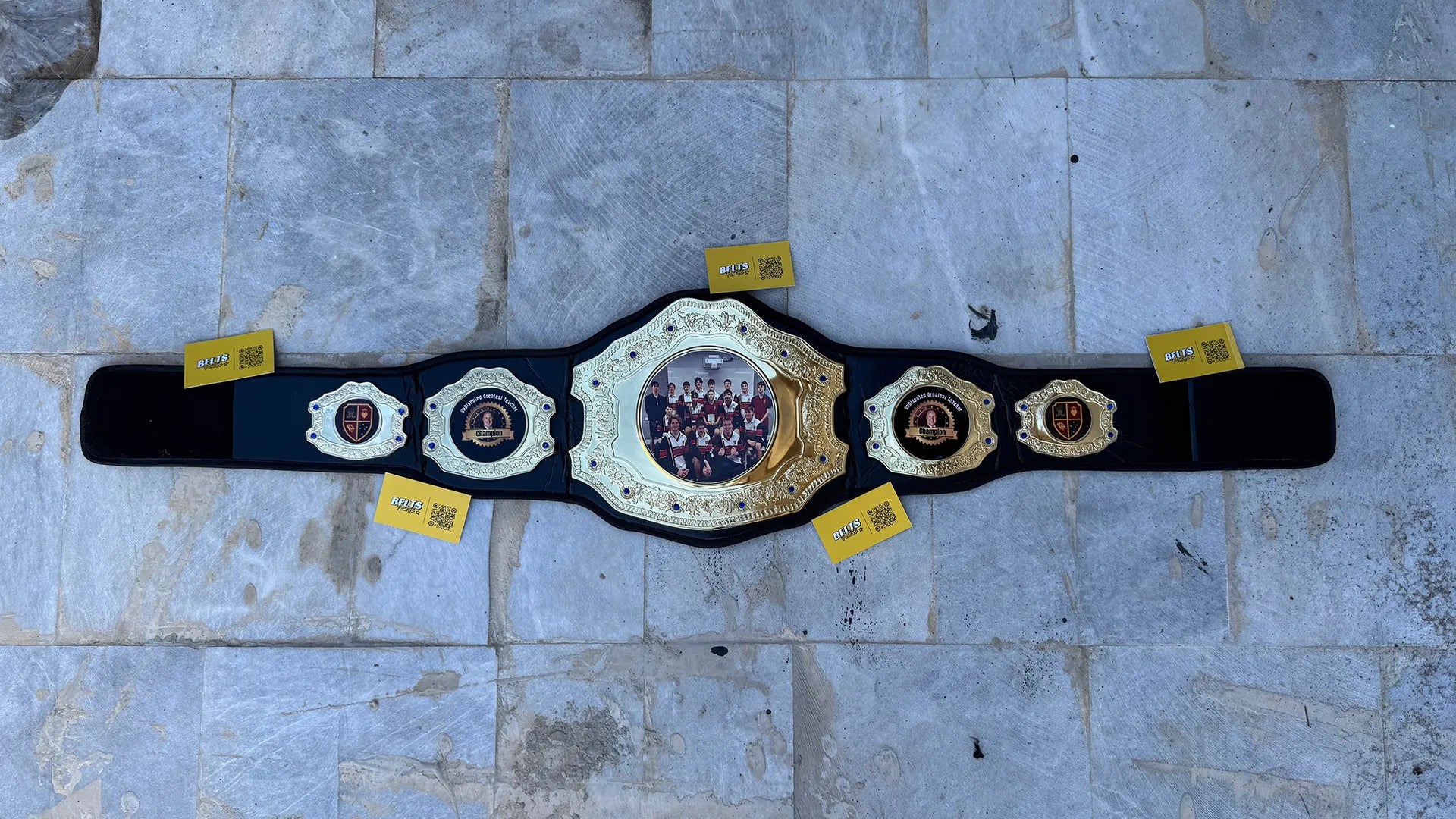 Custom Greatest Teacher Championship Belt full overhead flat lay display showing all die cast plates