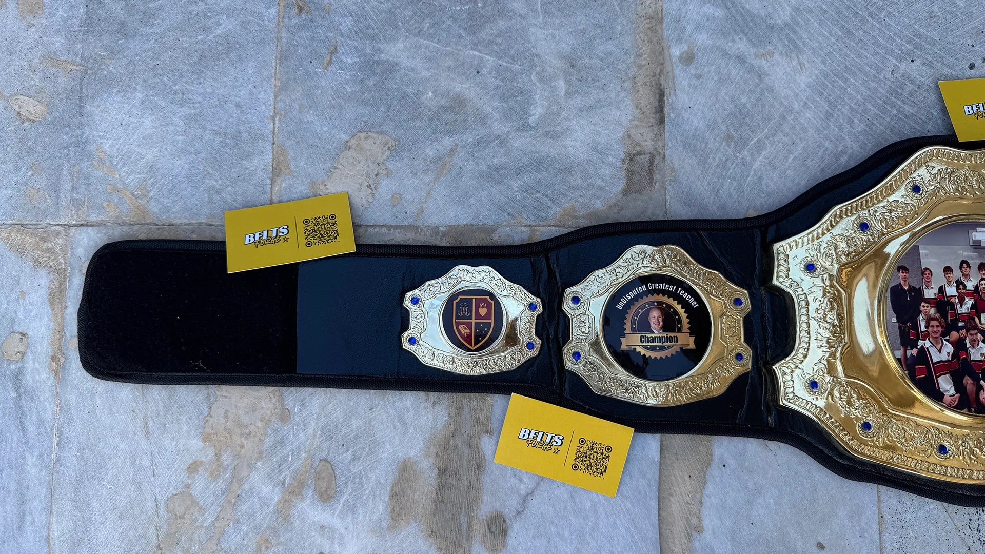 Custom Greatest Teacher Championship Belt left strap showing school crest and teacher side plates
