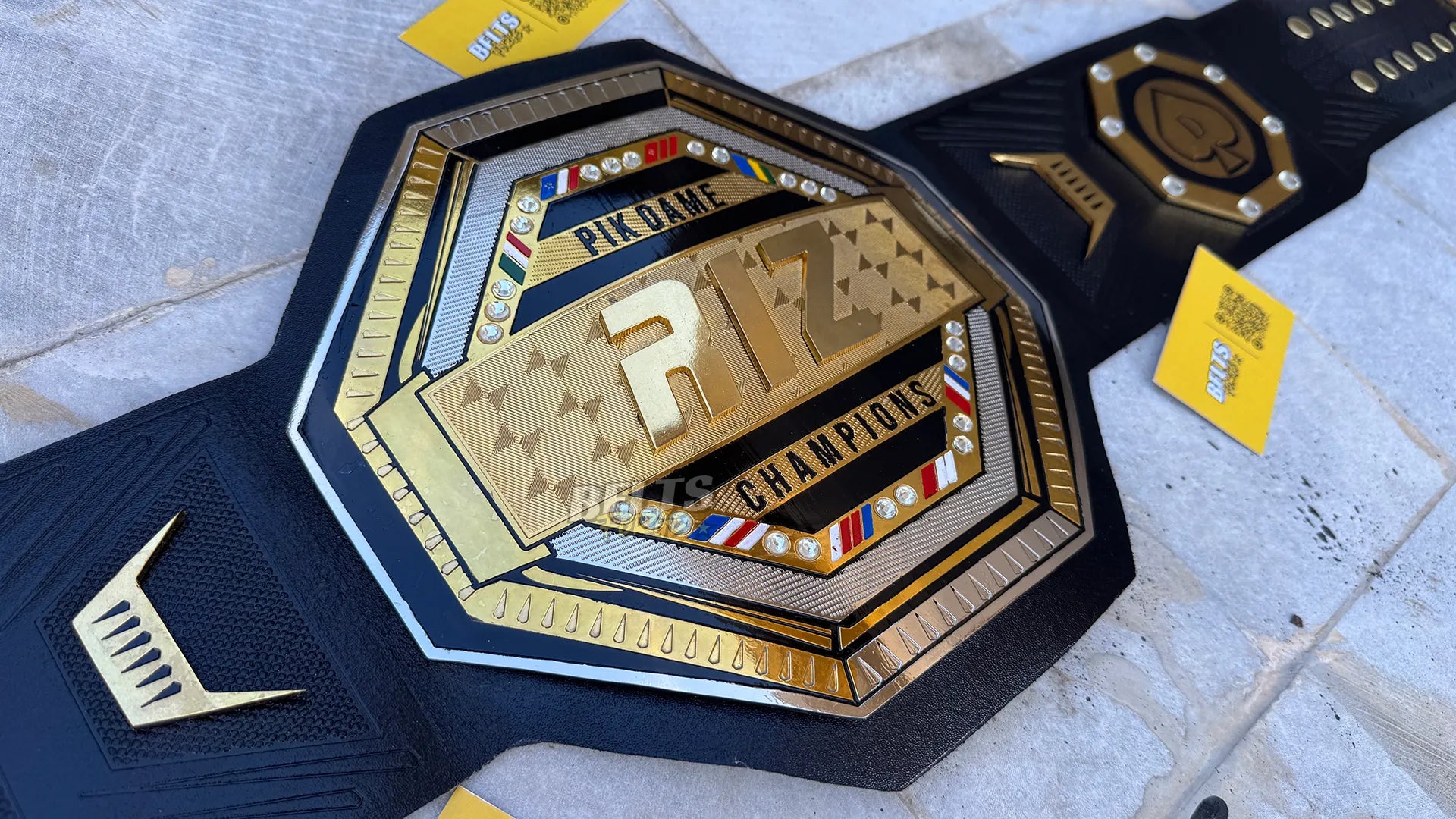 Custom UFC style championship belt center plate angled close up showing custom club branding on octagon design