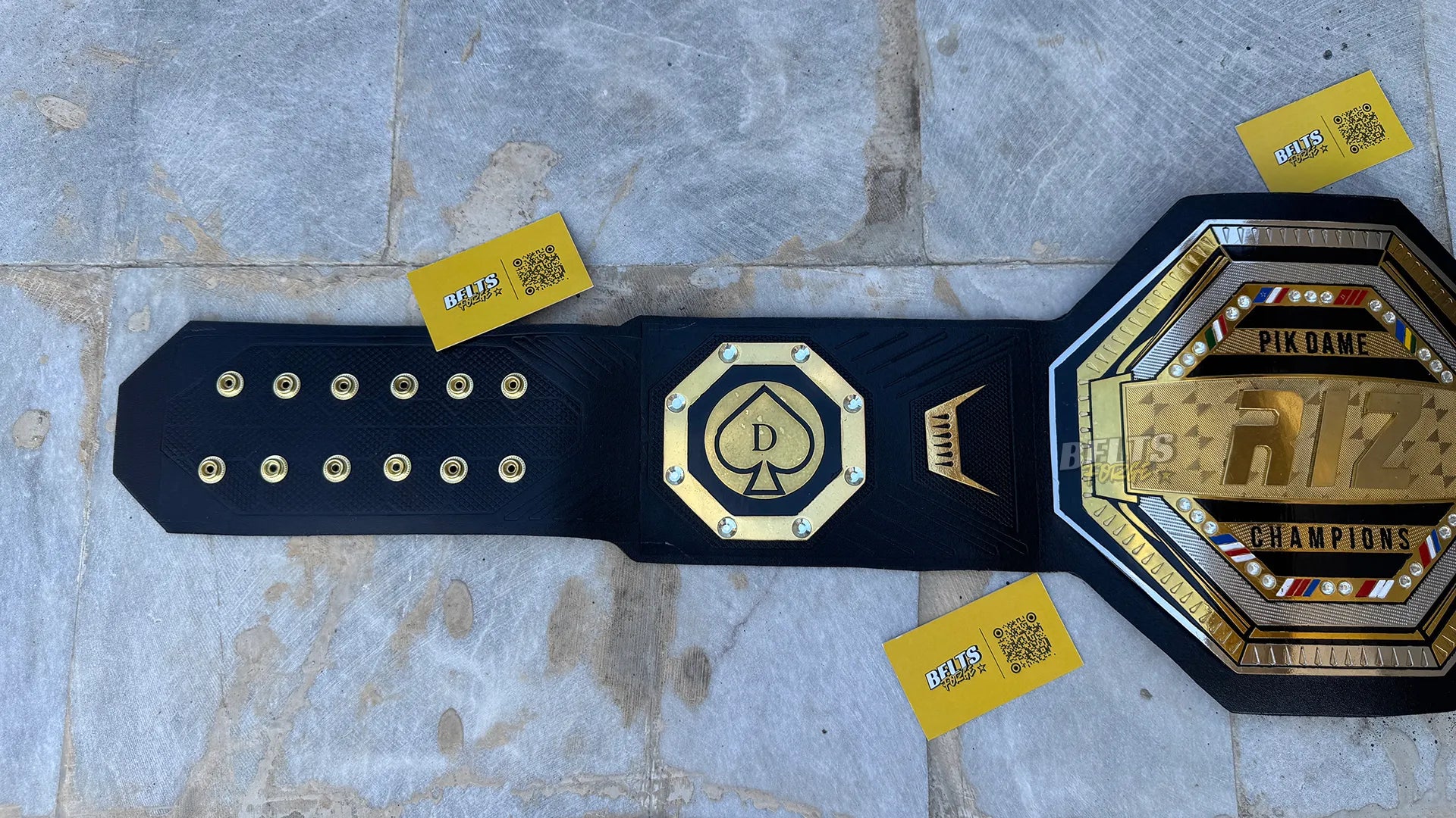 Custom UFC style championship belt left strap showing spade side plate and adjustment holes detail