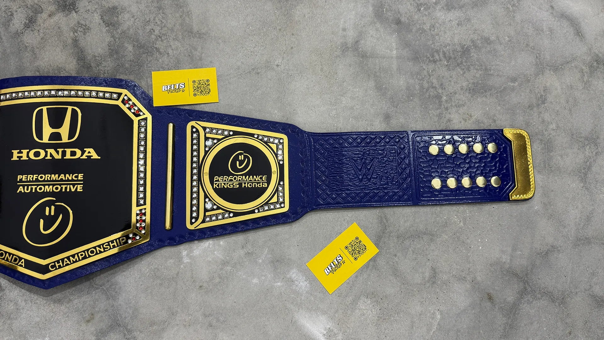 Honda Performance Kings Dealership Championship Belt strap and side plate detail showing gold hardware on genuine blue leather strap