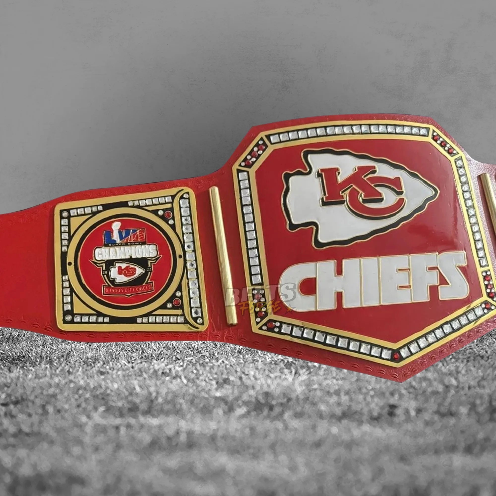 Kansas City Chiefs championship belt angled plate close-up showing CNC-engraved gold-plated brass Chiefs logo design