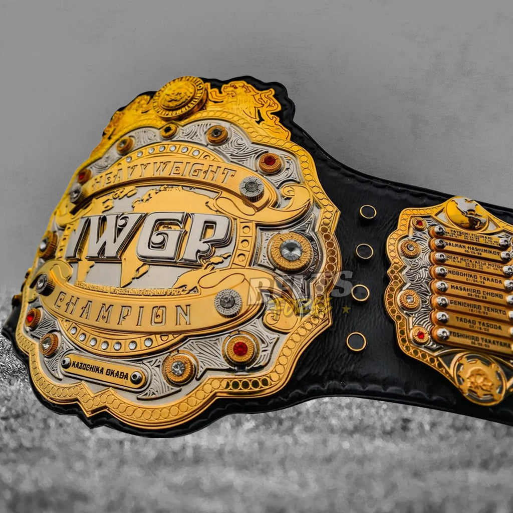 IWGP Heavyweight Championship V4 Belt angled center plate view showing Okada era nameplate and gold-plated brass detail