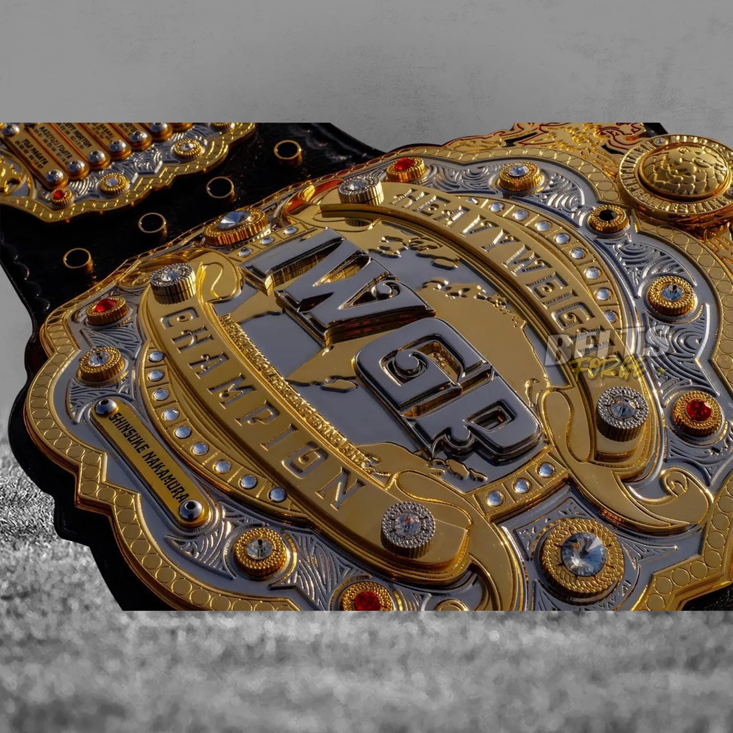 IWGP Heavyweight Championship V4 Belt center plate extreme close-up showing Nakamura nameplate and layered brass detail