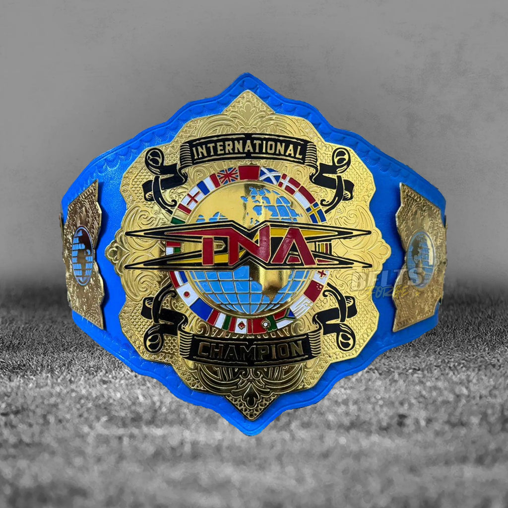 TNA International Championship Belt full front view close-up showing gold-plated brass TNA plate and blue leather strap detail