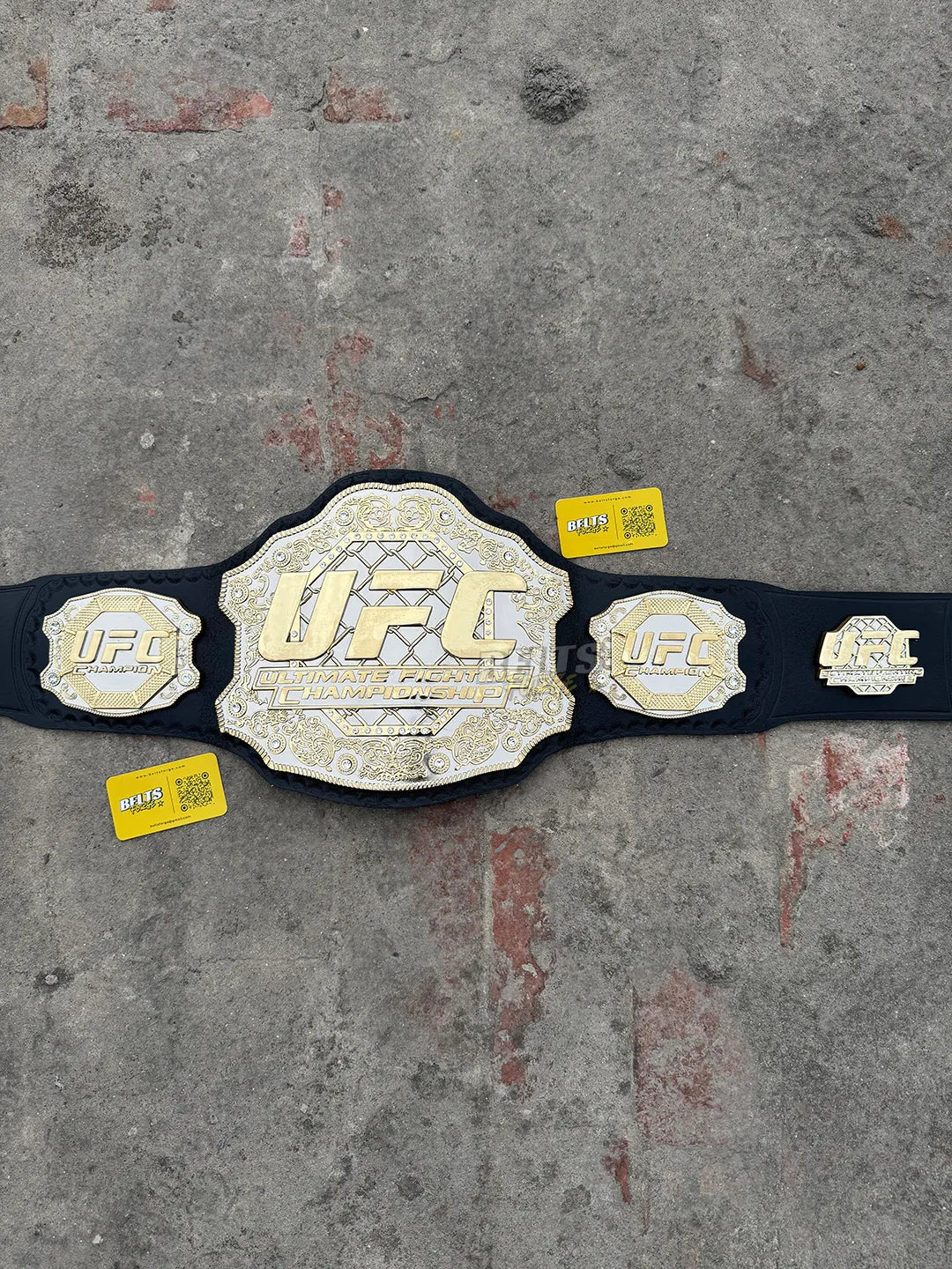 UFC Classic Championship Belt replica overhead flat lay, silver scrollwork and gold filigree main plate full view