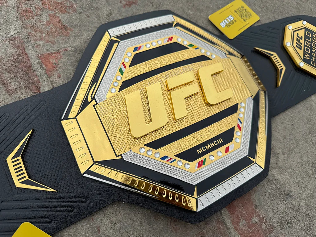 UFC Legacy Championship Belt main plate close-up, CNC-engraved gold brass octagon with MCMHCIII engraving and crystal rhinestones