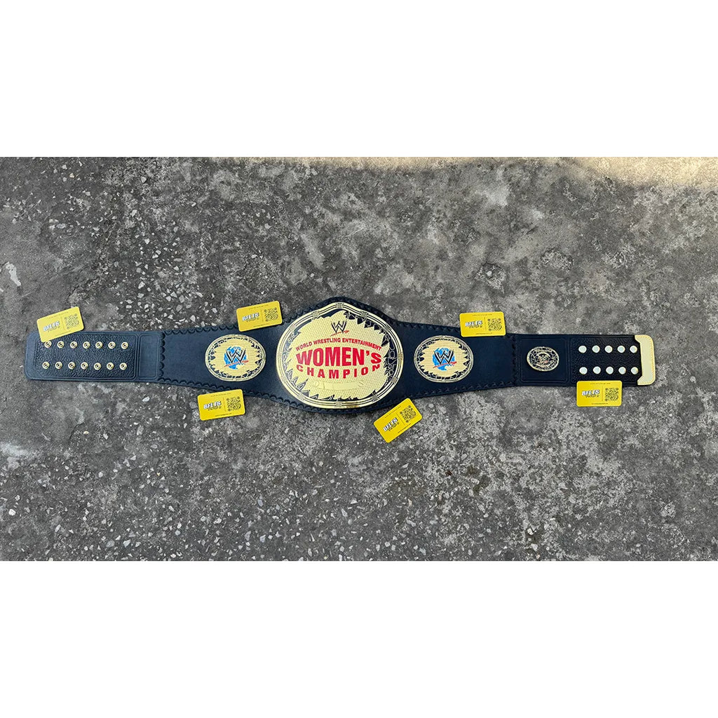 CNC-engraved gold brass plate close-up on women's wrestling heavyweight championship belt