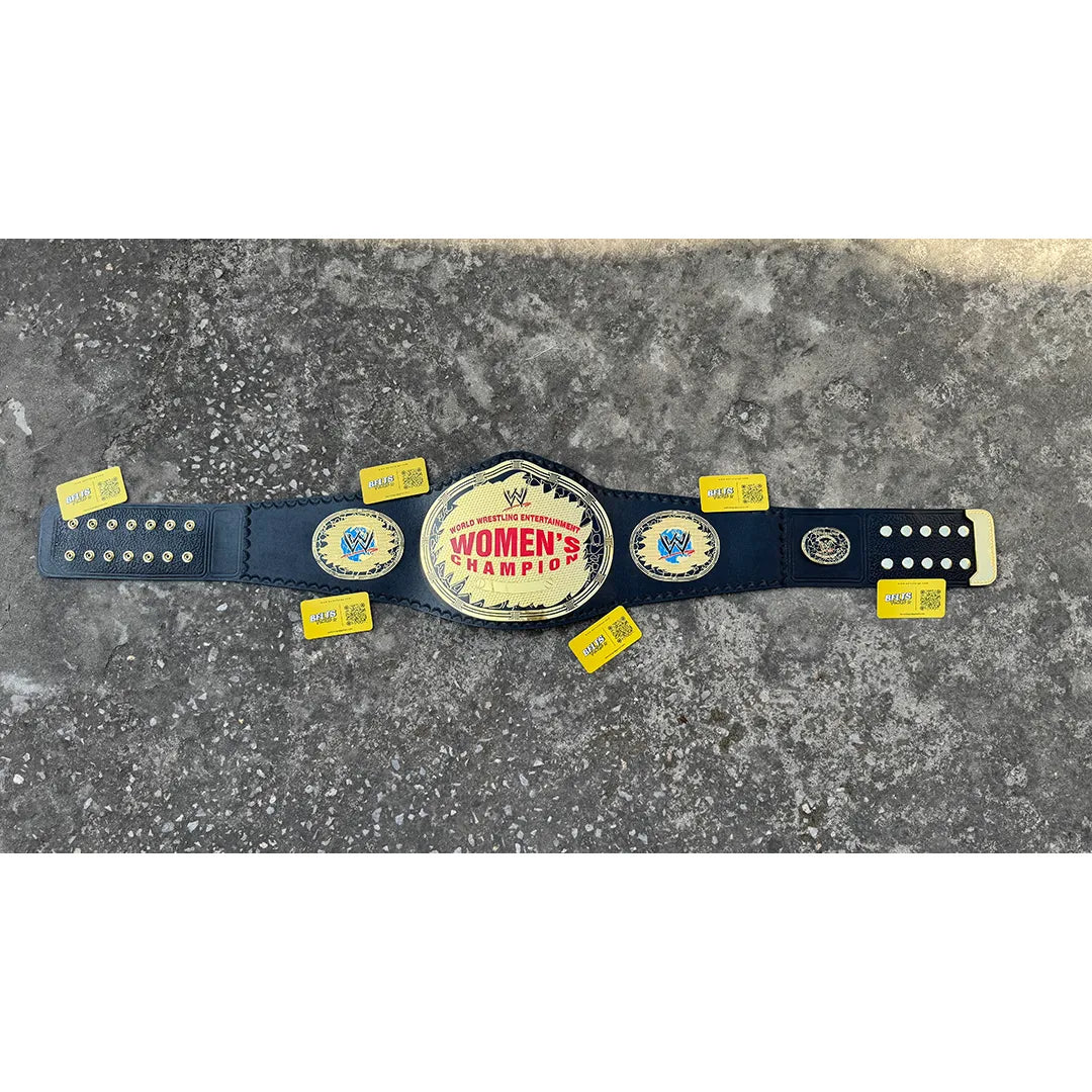 CNC-engraved gold brass plate close-up on women's wrestling heavyweight championship belt