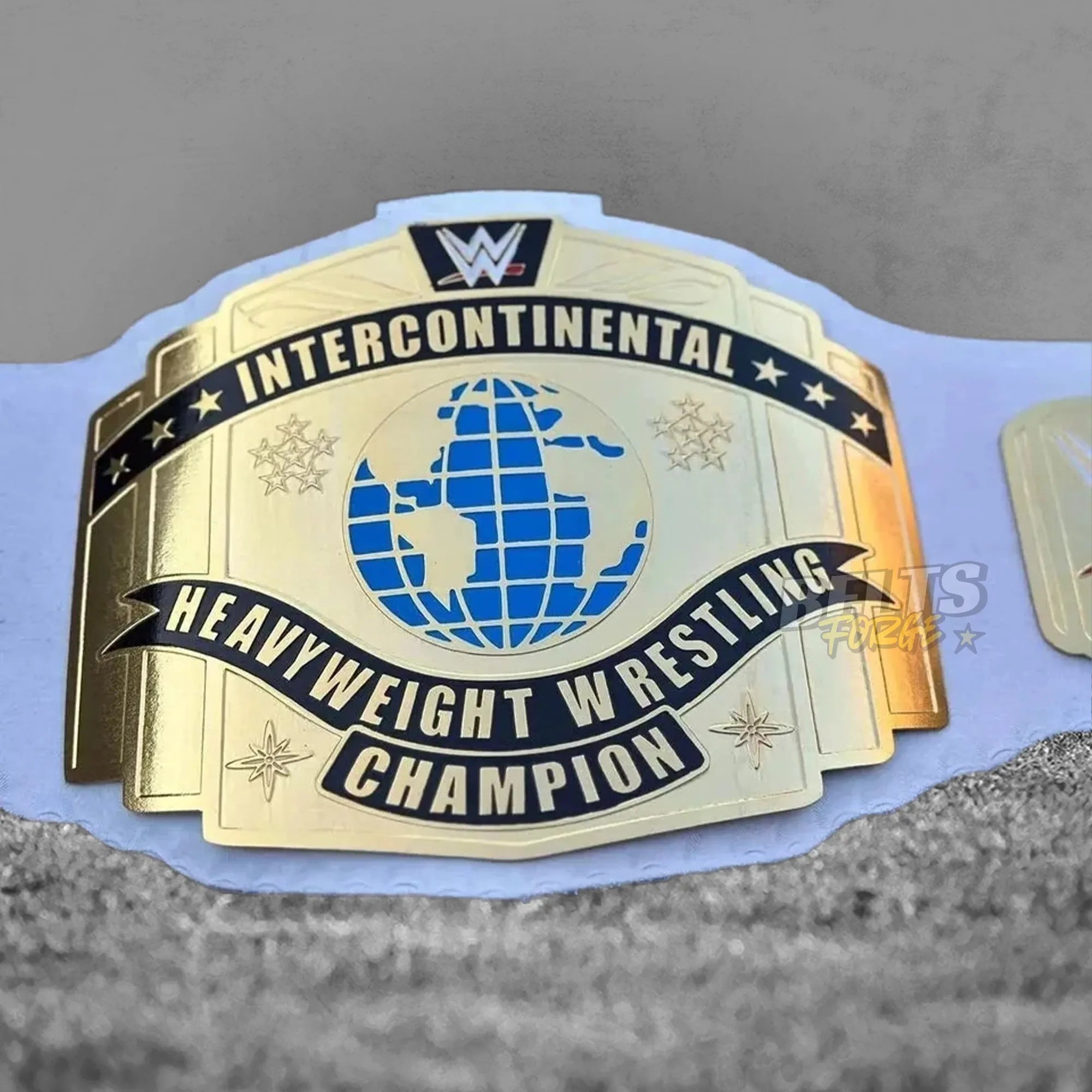 Intercontinental championship belt center plate detail showing CNC-engraved gold-plated brass with deep relief engraving