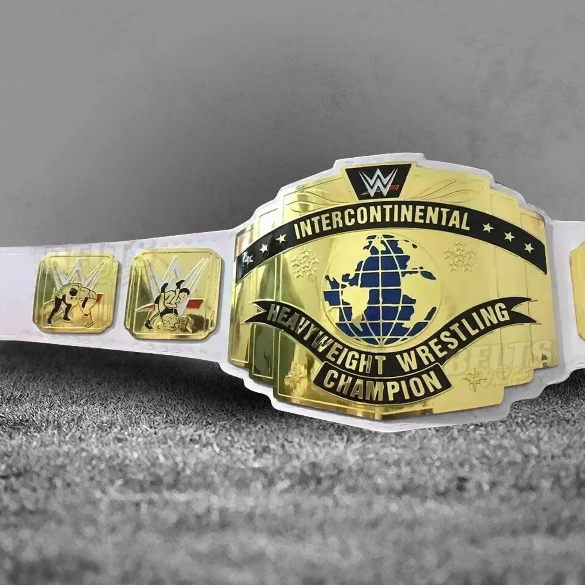 Intercontinental Championship Belt white strap angled center plate view showing gold-plated brass IC design on white leather