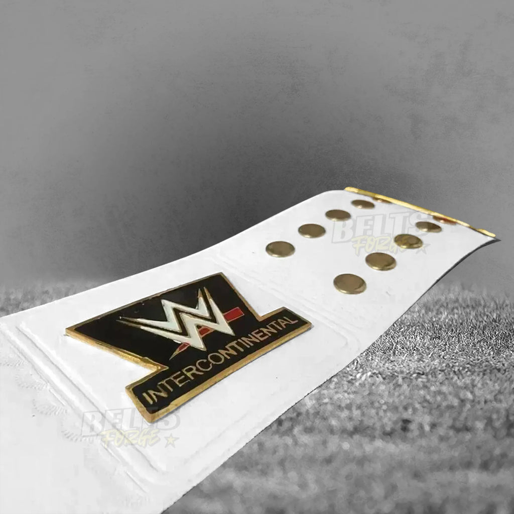 Intercontinental Championship Belt strap end and IC badge detail showing gold hardware and IC plate on white leather strap tip
