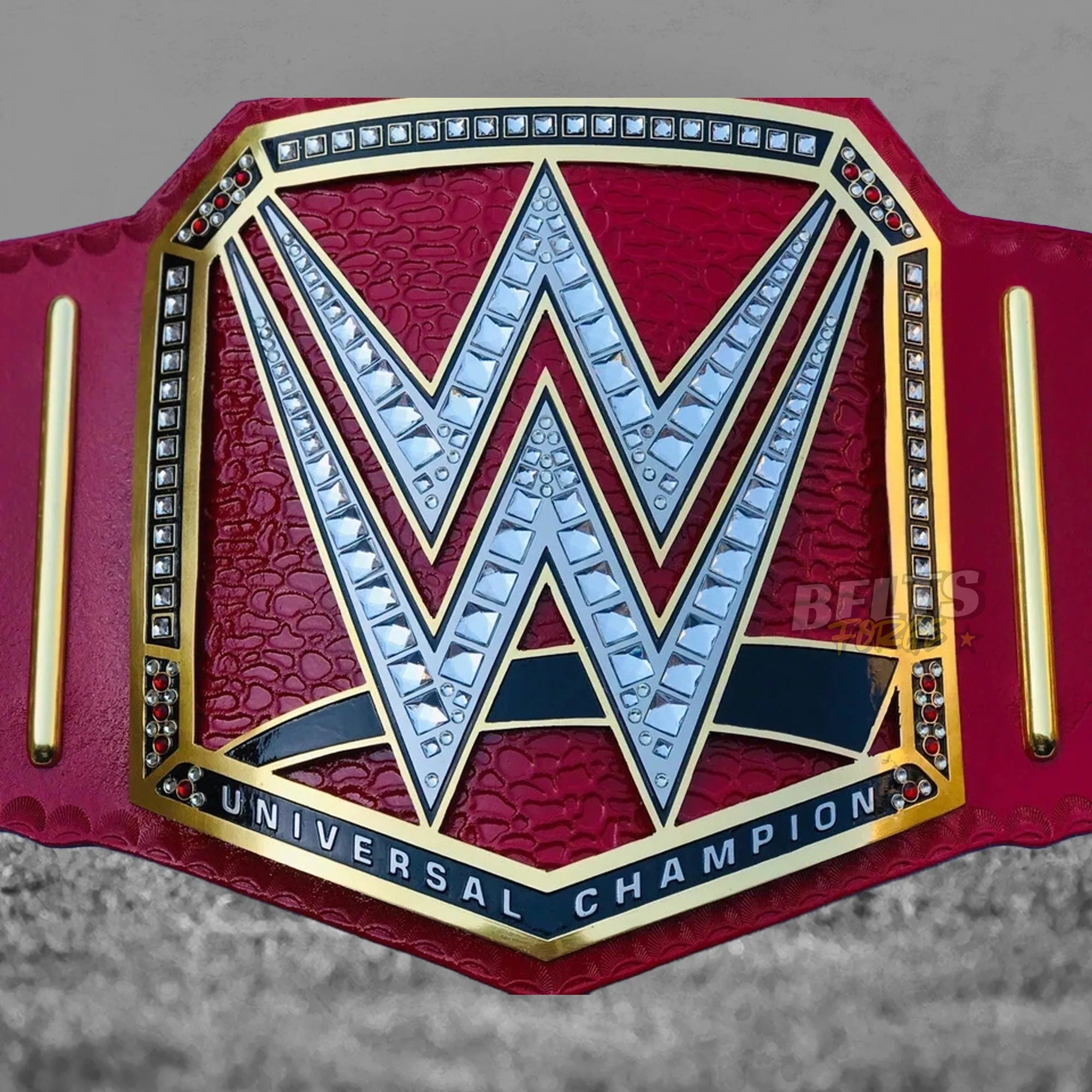 Pink Universal Championship Belt center plate detail showing CNC-engraved gold-plated brass Universal Championship globe design