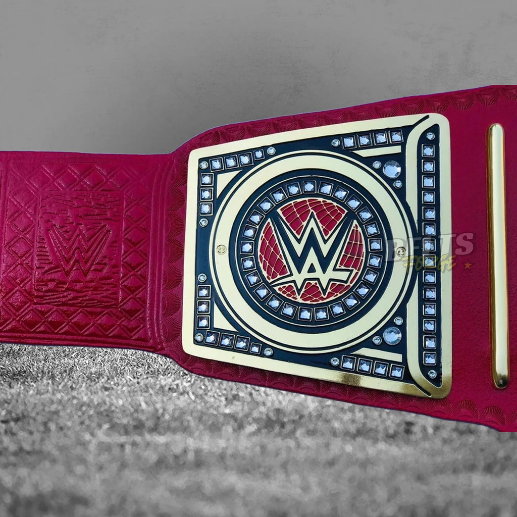 Pink Universal Championship Belt side plate close-up showing gold brass engraving detail on pink leather strap