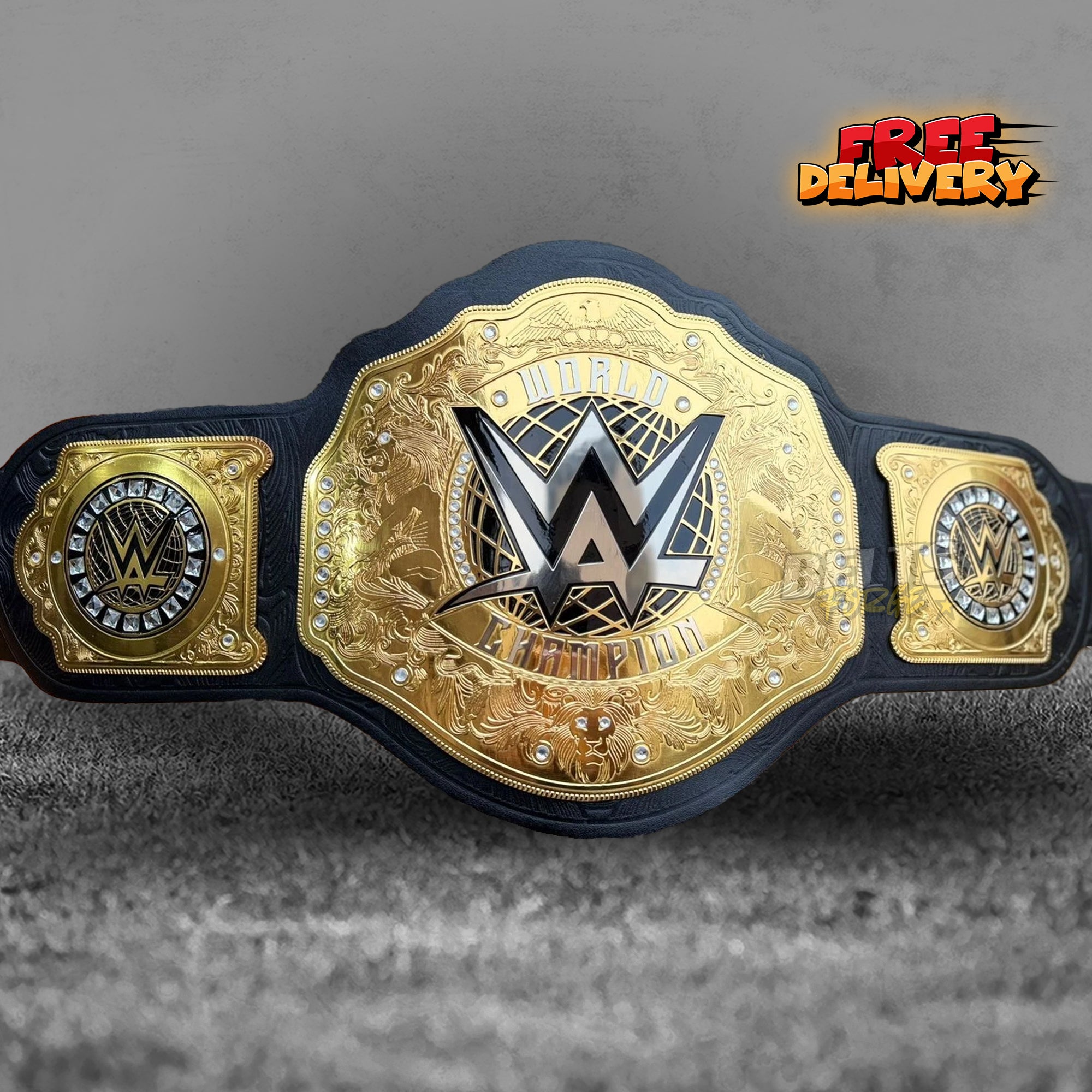 WWE World Heavyweight Championship Belt replica front view, gold-plated brass main plate with WWE logo, World Champion inscription, rhinestone border and lion head on black leather strap