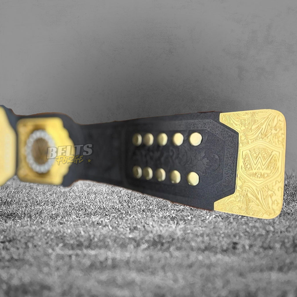 WWE World Heavyweight Championship Belt strap tip close-up showing gold-engraved WWE end plate, adjustment holes and floral embossed genuine black leather