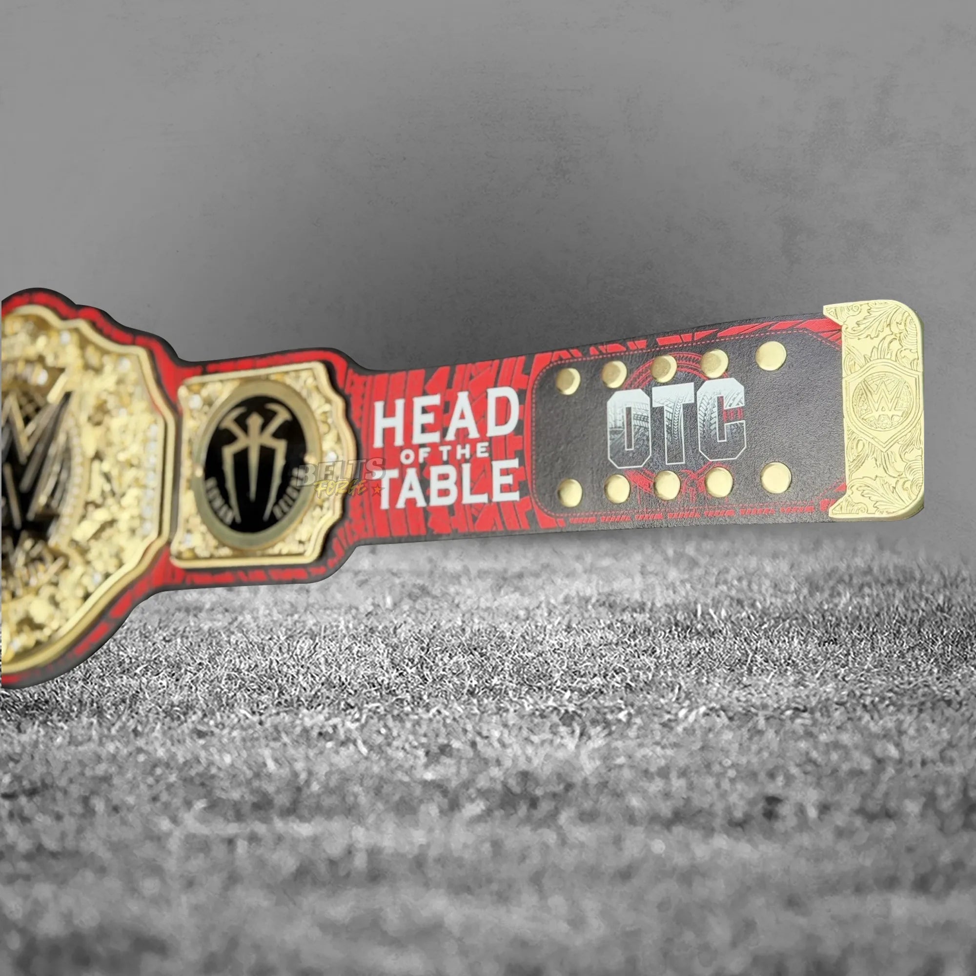 Roman Reigns plate close-up showing gold-plated brass tribal shield design and Head of the Table inscription engraving