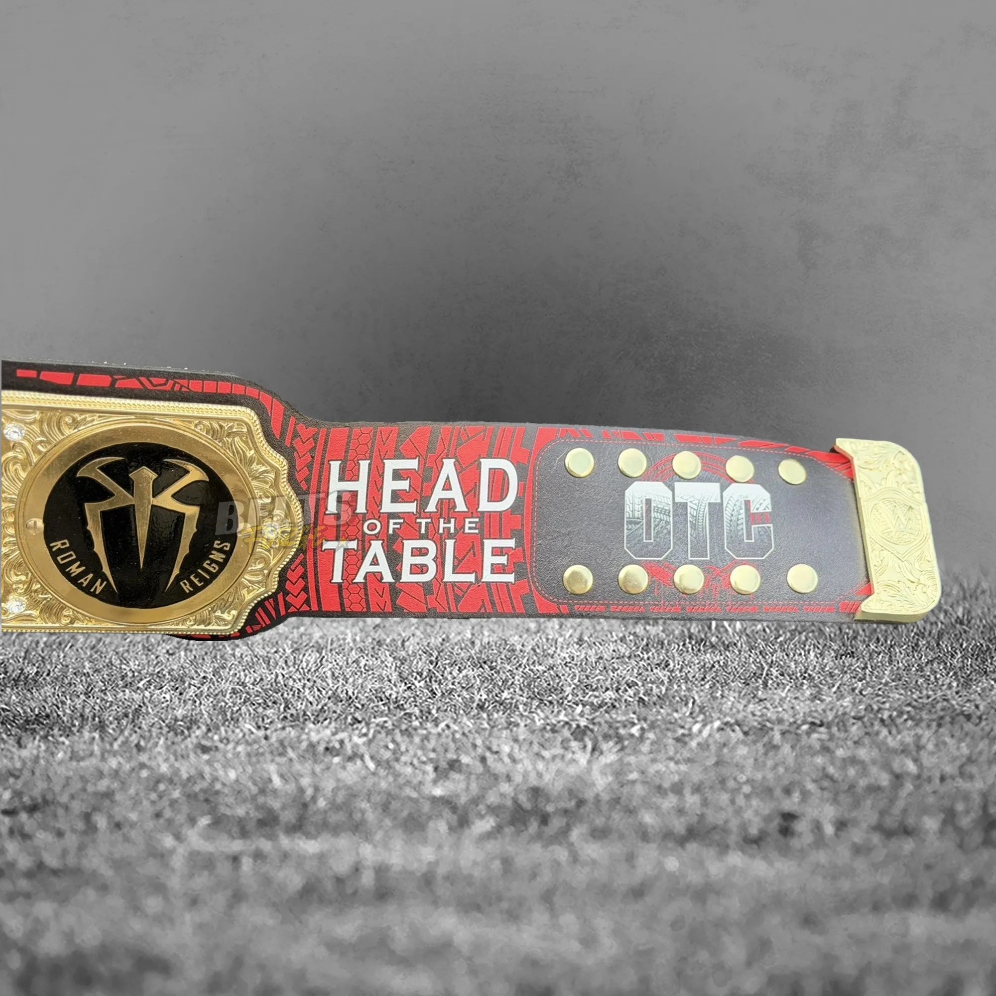 Roman Reigns championship belt strap angle detail showing tribal print leather strap and side plate from side perspective
