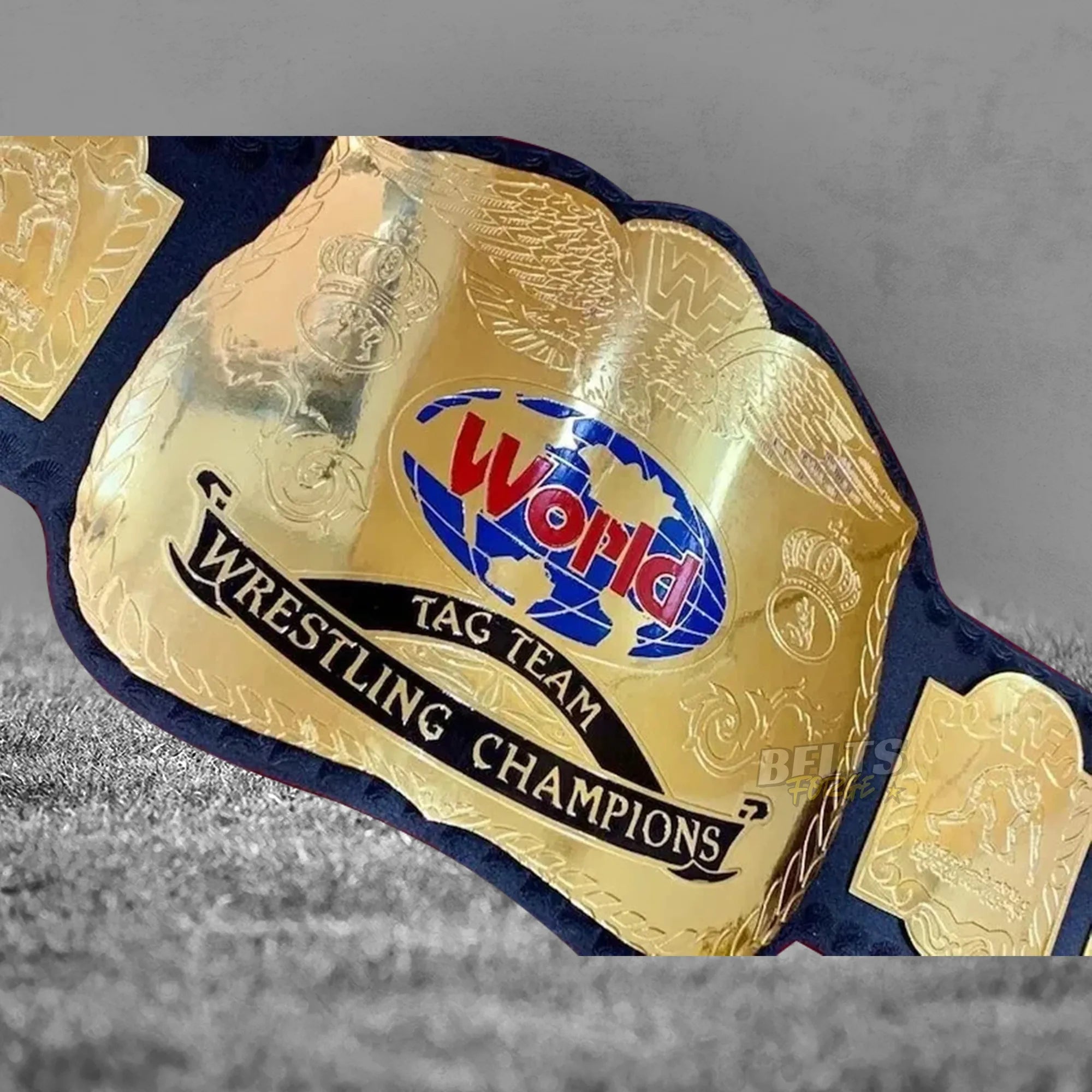 Golden Era Tag Team Championship Belt center plate angled close-up showing CNC-engraved gold-plated brass globe design detail