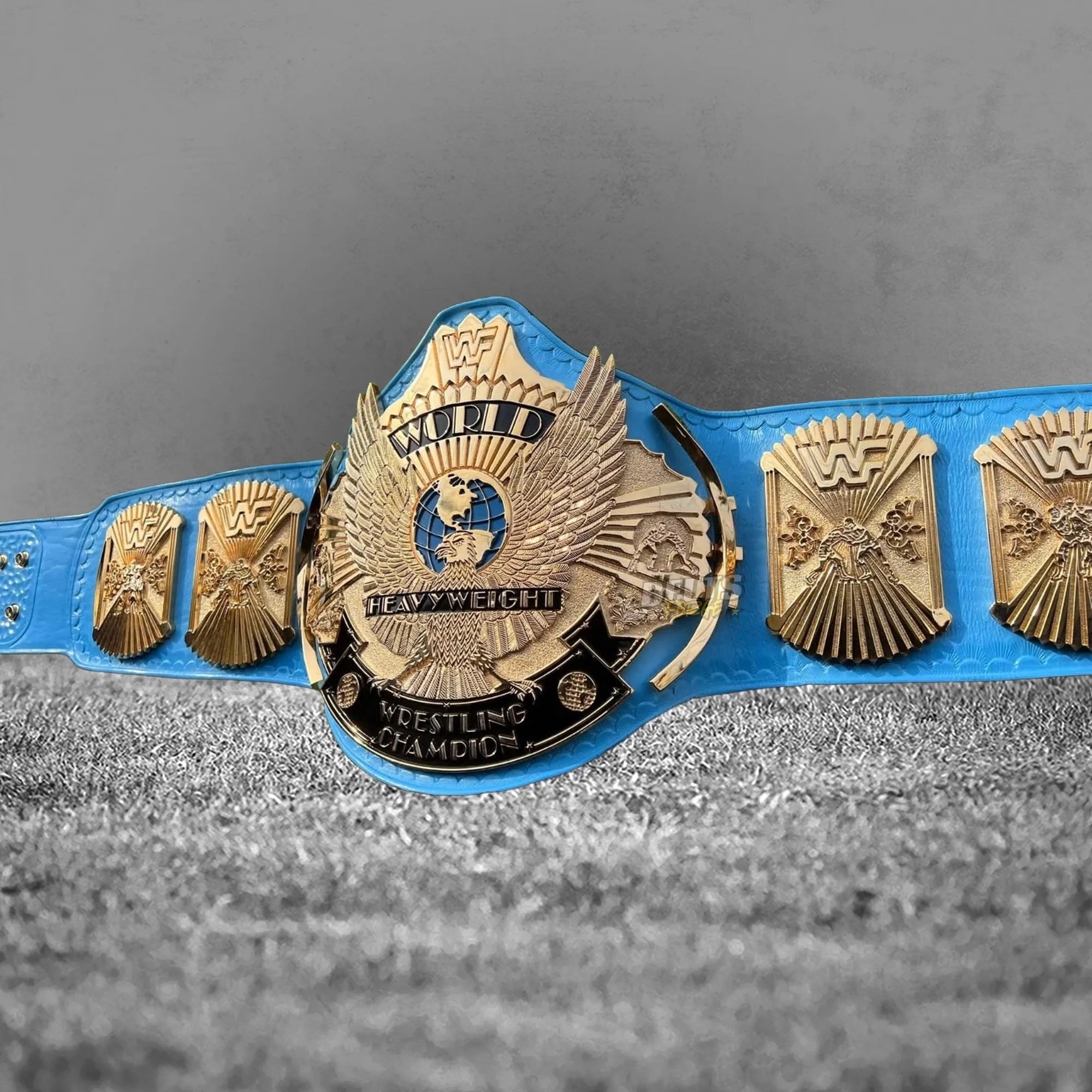 Winged Eagle Championship Belt full front view showing gold-plated eagle main plate and globe side plates on blue leather strap