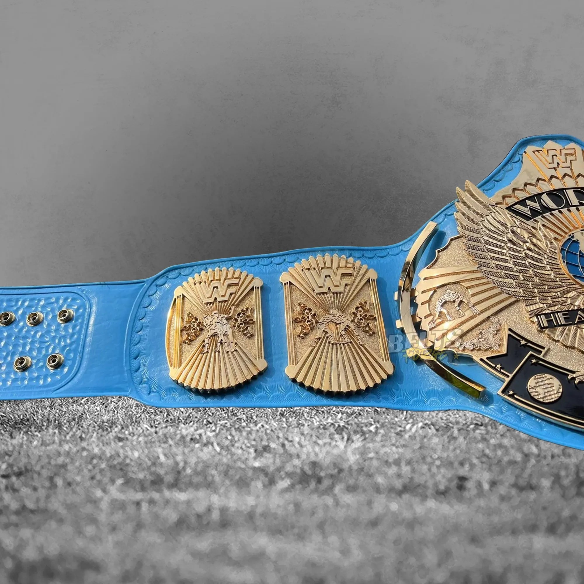 Winged Eagle Championship Belt strap buckle and side plates view showing gold globe side plates on genuine blue leather strap